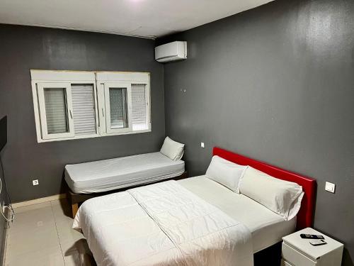 a bedroom with two beds and two windows at Hostal Gracias in Madrid