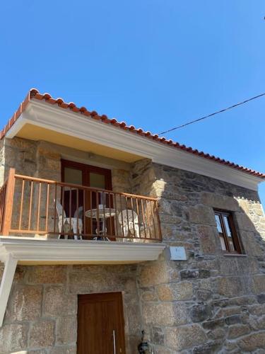 a building with a balcony with a table and chairs on it at Casa do Cruzeiro in Santo Adrião
