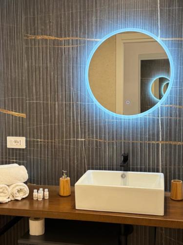 a bathroom with a white sink and a mirror at Duomo Rooms - Manfredi Homes&Villas in Manfredonia