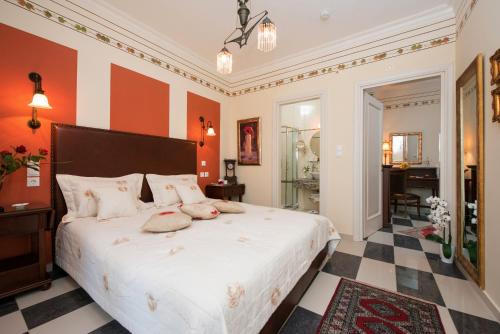 a bedroom with a large white bed with red walls at Enavlion Hotel in Chrysi Ammoudia