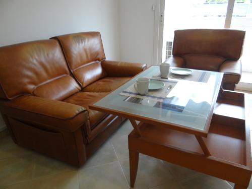 - un salon avec un canapé en cuir et une table basse dans l'établissement Azur Horizons Sea and Mountain, à Juan-les-Pins