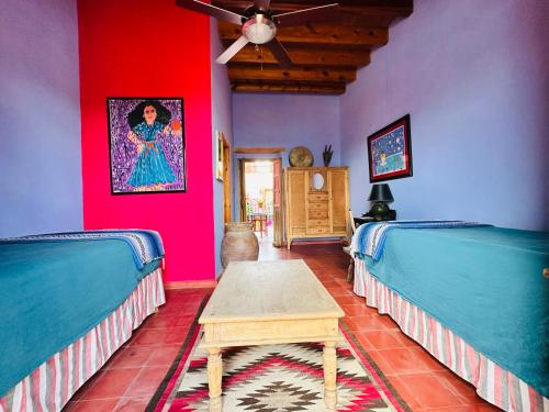 a room with two beds and a table in it at Posada de la Cruz#2 in Querétaro
