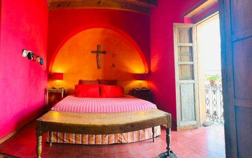 a bedroom with a bed with a cross on the wall at Posada de la Cruz#2 in Querétaro