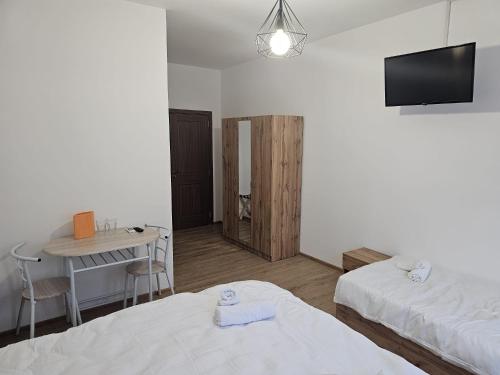 a room with two beds and a desk and a tv at Casa Dragoste in Someşu Cald