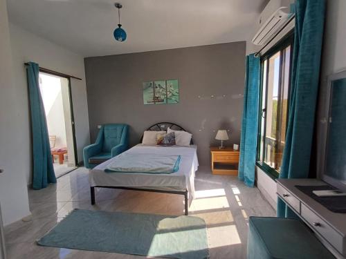 une chambre avec un lit, un canapé et une télévision dans l'établissement Holiday Apartment in Sunshine - Naama Bay, à Charm el-Cheikh