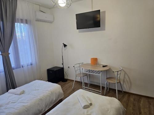a room with two beds and a table and a tv at Casa Dragoste in Someşu Cald