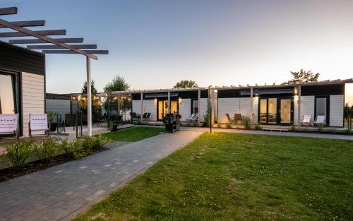 a building with a lawn in front of it at Resto domki letniskowe in Sarbinowo