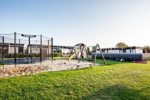 a playground in a park with a slide at Resto domki letniskowe in Sarbinowo