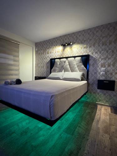 a bedroom with a large white bed with green floors at Atlas appartement in Fez