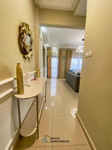 a room with a table and a mirror on the wall at Scale Apartments in Douala