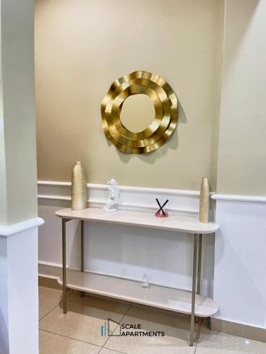 a dressing table with a gold mirror on the wall at Scale Apartments in Douala