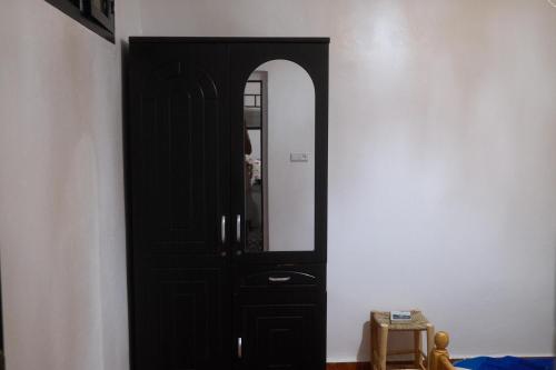 a black door with a mirror on a wall at Black Pearl surf yoga and skate house in Tamraght Ouzdar
