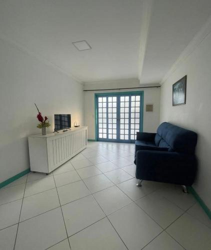 a living room with a blue couch and a television at Recanto dos Valles in Búzios