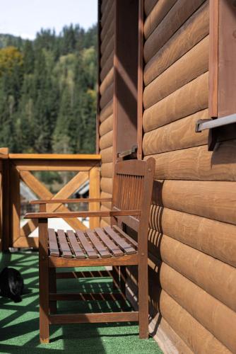a wooden bench sitting on the porch of a house at Aura Karpat in Bukovel