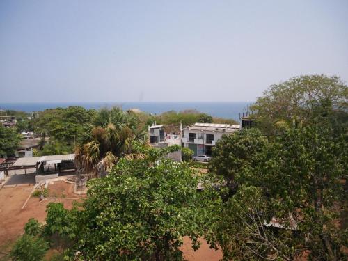 a view of a city with trees and houses at Madre Tierra Hostal in Puerto Escondido