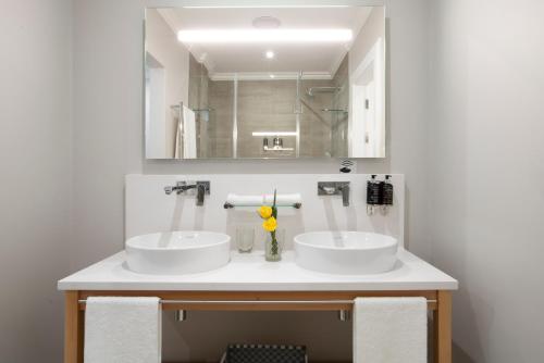 约翰内斯堡Studio Stay on Sixty6的浴室设有2个白色水槽和镜子