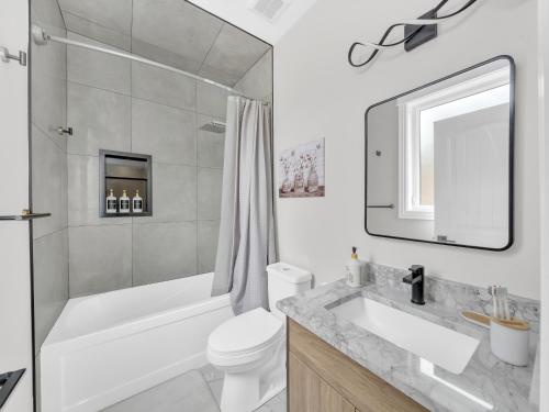 a bathroom with a tub and a toilet and a sink at 5 Bedrooms Modern Oasis in Downtown Area in Windsor