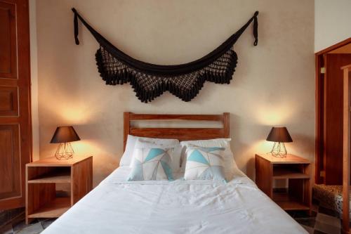 a bedroom with a white bed with two nightstands and two lamps at Hotel Boutique Casa Jade in Campeche