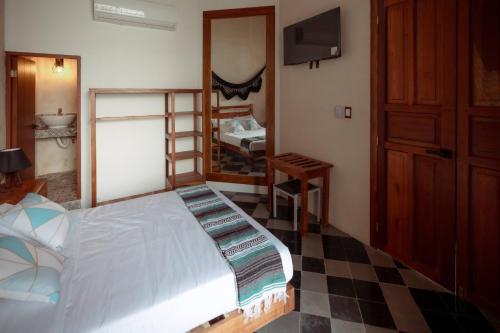 a bedroom with a bed and a bathroom with a sink at Hotel Boutique Casa Jade in Campeche