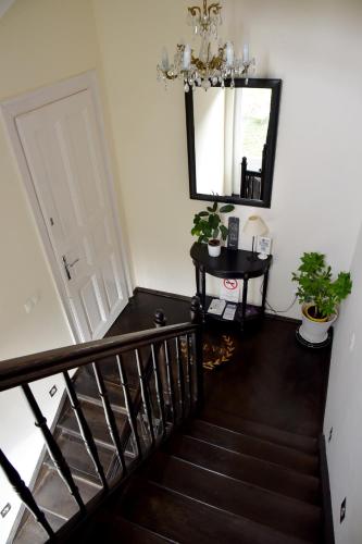 a hallway with a staircase with a mirror and a chandelier at VILLA GIULIETTA BUDAPEST with GARDEN, FREE PARKING in Budapest