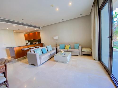 a living room with two couches and a table at Nayah Stays, Ancient Sands Luxurious Pool Terrace Apartment in Hurghada