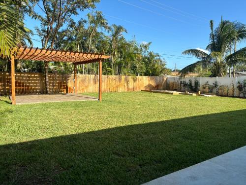 een tuin met een houten pergola en een hek bij House in Dania beach in Dania Beach