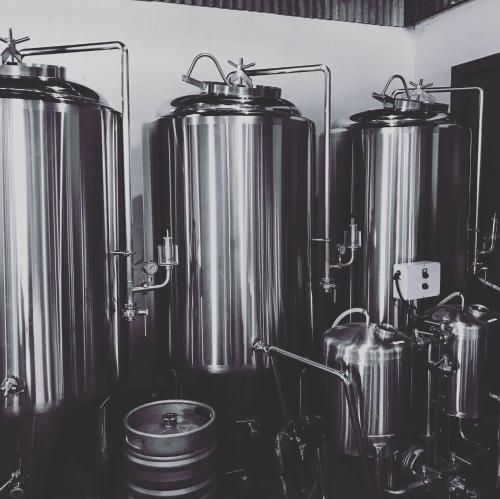 a row of metal tanks sitting in a kitchen at Fjordside Retreat Lodge in Breiðdalsvík