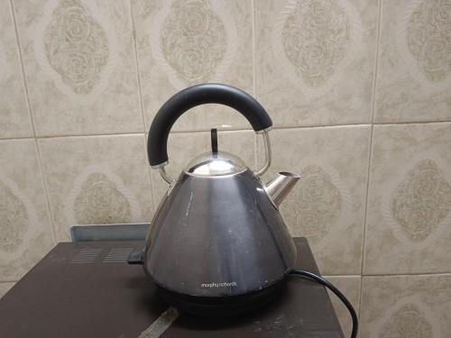 a tea kettle sitting on top of a stove at Luhasa second floor apartment in Ngambo