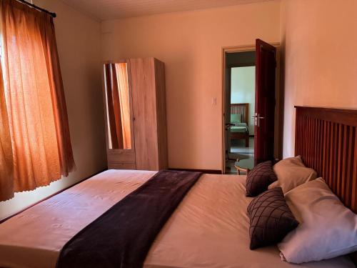 a bedroom with a large bed with pillows on it at Arcton Apartment in Paramaribo