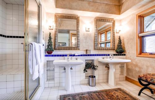 a bathroom with two sinks and two mirrors at Luxury Lodge with Breathtaking Views in Telluride