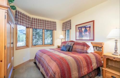 a bedroom with a bed and two windows at Luxury Lodge with Breathtaking Views in Telluride