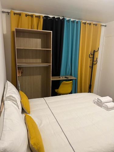 Cette chambre comprend un lit avec des rideaux jaunes et bleus. dans l'établissement Appartement R, à Béziers