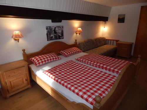 a bedroom with a bed with a red and white checkered blanket at Thorau Alm Comfortable in Ruhpolding