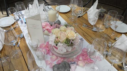 a wooden table with a centerpiece of flowers and wine glasses at Hotel-Restaurant Pfälzer Hof in Edenkoben