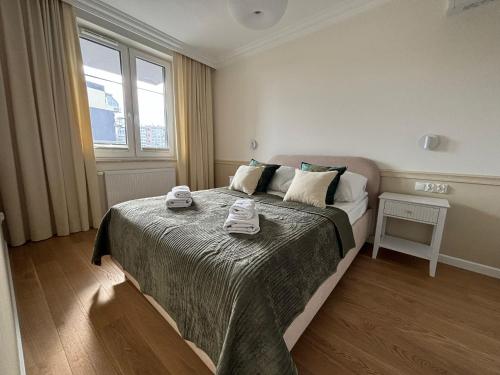 a bedroom with a bed with two towels on it at Apartamenty w centrum Białegostoku z parkingiem w garażu podziemnym in Białystok