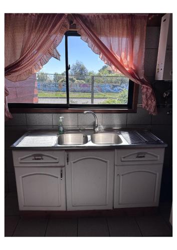 una cucina con un lavandino e una finestra di Cabañas Paihuén a Pucón
