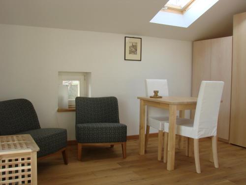 ein Zimmer mit einem Tisch und 2 Stühlen sowie einem Tisch und Stühlen in der Unterkunft Ferienwohnungen Spiesmacher in Strodehne