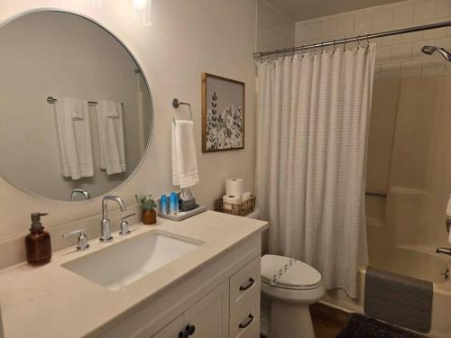 Un baño con lavabo, inodoro y espejo. en Destin Bliss, en Destin