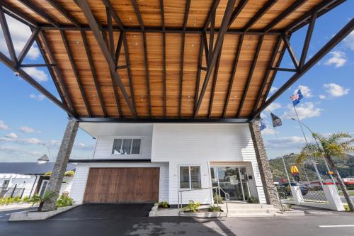 a white house with a wooden roof at Newina Rotorua in Rotorua