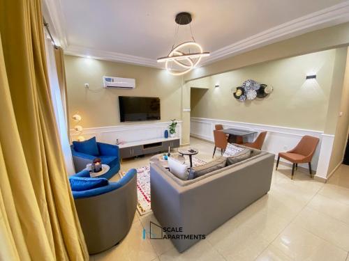 a living room with a couch and a tv at Scale Apartments in Douala