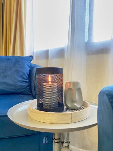 a candle on a table in front of a couch at Scale Apartments in Douala