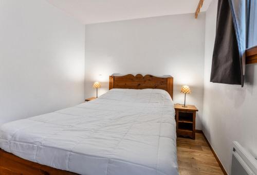 une chambre avec un grand lit blanc avec deux lampes dans l'établissement Résidence Les Hauts De Preclaux - Appartement au coeur des Orres 1800 MAE-0741, aux Orres