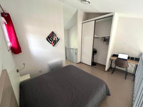 une chambre avec un lit et un bureau avec un ordinateur portable dans l'établissement Domaine de Bacchus-Villa Occitane-Climatisée 4 couchages, à Saint-Christol