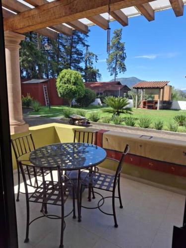 a table and chairs on a porch with a table and chairs at Las casas de las flores in Ibarra