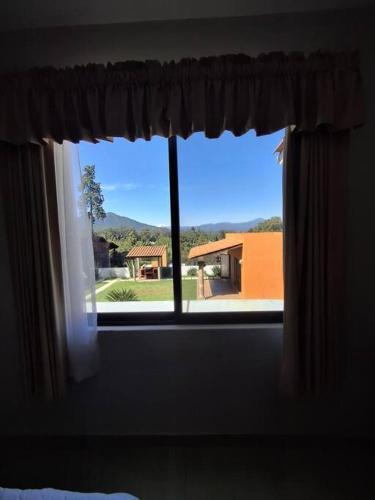 a bedroom window with a view of a house at Las casas de las flores in Ibarra
