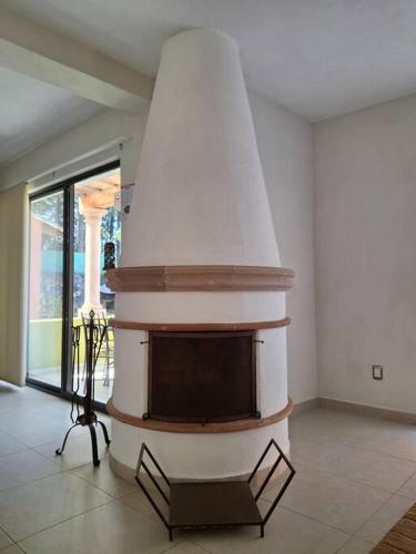a living room with a fireplace with a tv at Las casas de las flores in Ibarra