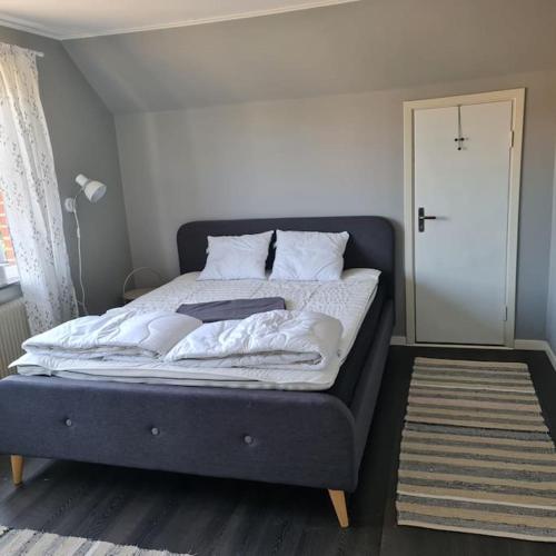 a bedroom with a large bed with a door at Lägenhet i Hestra in Hestra