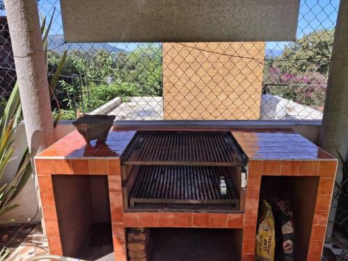 a grill in a patio with a fence at Las casas de las flores in Ibarra