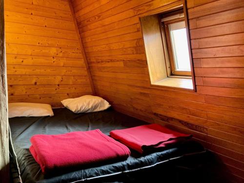 Cette chambre en bois dispose d'un lit et d'une fenêtre. dans l'établissement Résidence Meijotel - Studio résidence Meijotel MAE-9321, à Vénosc