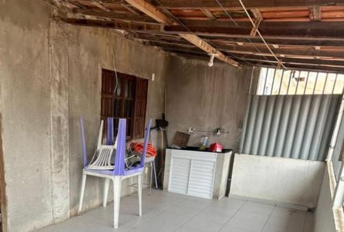 a room with a table and a blue chair at Apartamento Piuma ES in Piúma